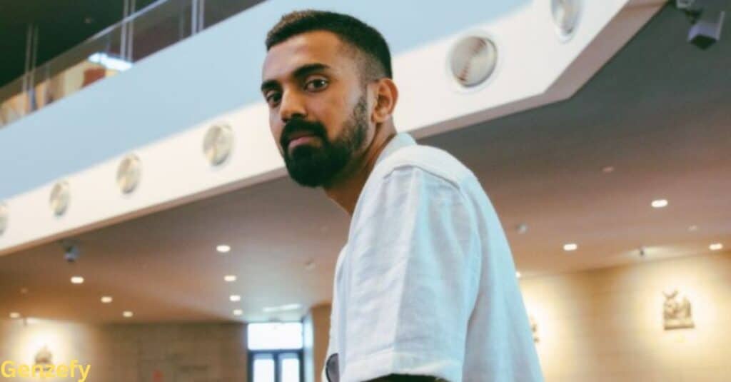KL Rahul, a man with a beard, is wearing a white t-shirt and looking directly at the camera.